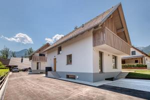 a large white house with a balcony and a driveway at Bohinj Rentals Twin Villas in Bohinj