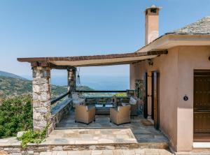 a patio of a house with a table and chairs at A Dream Deferred villa Pelion in Kissos