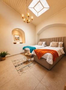two beds in a bedroom with a skylight at וילת הארי בעתיקה in Safed