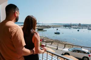 a man and a woman standing on a balcony looking at the water at Le Thalassa Hôtel & Spa in Camaret-sur-Mer +43 photos