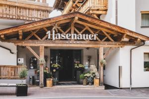 a sign for a restaurant on the front of a building at Hotel Hasenauer 4 Sterne Superior in Saalbach-Hinterglemm