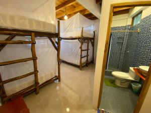 a room with two bunk beds and a toilet at HIDDEN HOSTAL MONTANITa in Montañita