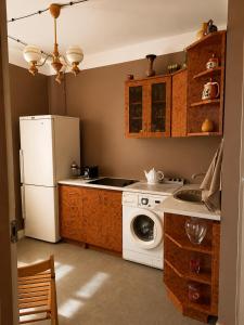 a kitchen with a white refrigerator and a washing machine at Arāja apartamenti in Kuldīga +17 photos