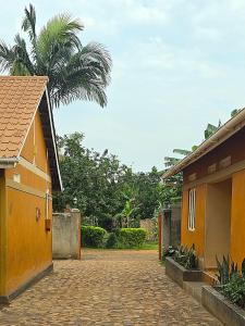 a courtyard with a building and a palm tree at MildVille Apartments in Hoima