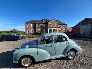 an old blue car parked in front of a house at Marehay Hall Farm in Belper