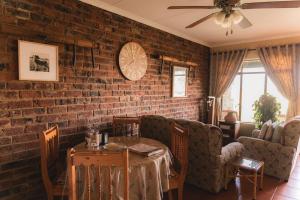 a living room with a brick wall and a table at Garingboom Guest Farm in Groot-Suurfontein +65 photos