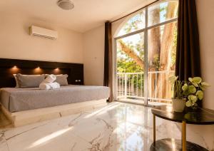 a bedroom with a bed and a large window at Hotel YA'AX HA' Bacalar in Bacalar