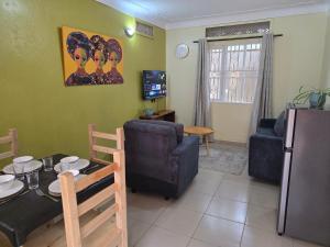 a kitchen and living room with a table and a refrigerator at MildVille Apartments in Hoima