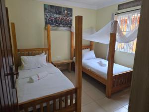 a bedroom with two bunk beds and a window at MildVille Apartments in Hoima