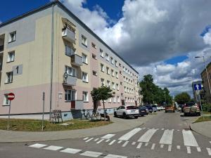 an apartment building on a city street with cars parked at Apartamenty Iława in Iława
