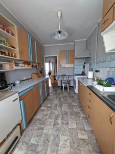 a kitchen with wooden cabinets and a tile floor at Apartamenty Iława in Iława +4 photos