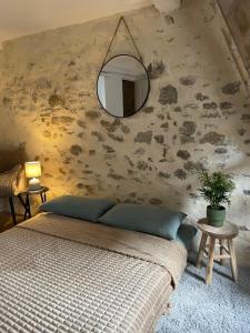 a bedroom with a bed and a mirror on the wall at Duplex de caractère in Coutances