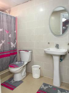 a bathroom with a toilet and a sink and a mirror at 3 dormitorios y confortable apartamento in Santo Domingo +13 photos
