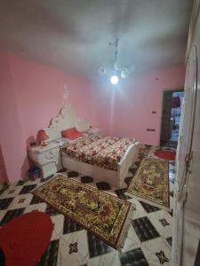 a bedroom with two beds and two rugs on the floor at Sobh safa holiday in Al Ghuşnah