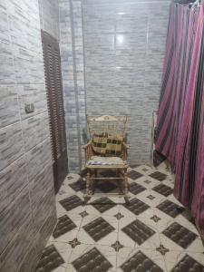 a chair sitting on a tiled floor in a room at Sobh safa holiday in Al Ghuşnah