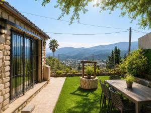 a patio with a table and chairs on the grass at וילת הארי בעתיקה in Safed
