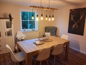 a dining room with a wooden table and chairs at Landliebe in Blomberg