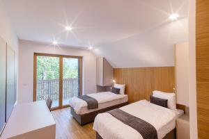 a bedroom with two beds and a balcony at Bohinj Rentals Twin Villas in Bohinj +97 photos