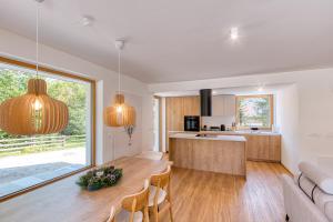 a kitchen and living room with a table and chairs at Bohinj Rentals Twin Villas in Bohinj
