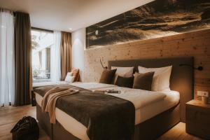 a bedroom with a large bed in a room at Landhaus Albert Murr inkl Premium Sommerkarte in Sankt Anton am Arlberg