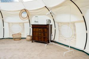 a room with a tent with a dresser in it at Kirsebærkroen - The Inn Between in Præstø