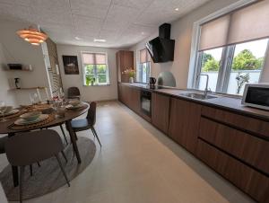 a kitchen with a table and a dining room at Kølkær B&B in Kølkær