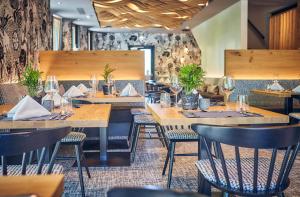 a dining room with wooden tables and chairs at Hotel Hasenauer 4 Sterne Superior in Saalbach-Hinterglemm +50 photos