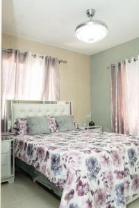 a bedroom with a bed with a floral bedspread at 3 dormitorios y confortable apartamento in Santo Domingo