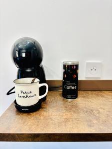 a coffee maker and a coffee cup on a counter at Le cocon d Albi in Albi