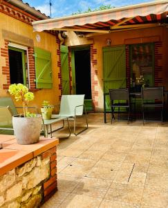 a patio with chairs and tables on a house at Le cocon d Albi in Albi