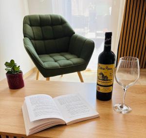 a bottle of wine and a book on a table with a glass at Le cocon d Albi in Albi