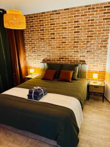 a bedroom with a large bed with a brick wall at Le cocon d Albi in Albi