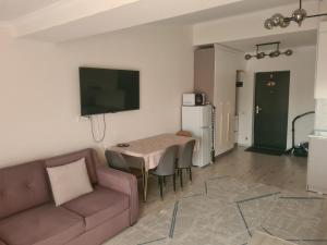 a living room with a couch and a table at Diona Raduga West in Koshkolʼ