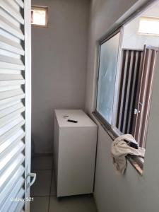 ein kleiner Kühlschrank in einem Zimmer mit Fenster in der Unterkunft Ney kitnet in Pirapora