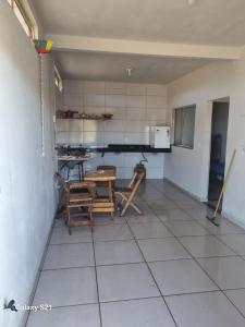 eine Küche mit Tisch und Stühlen in einem Zimmer in der Unterkunft Ney kitnet in Pirapora