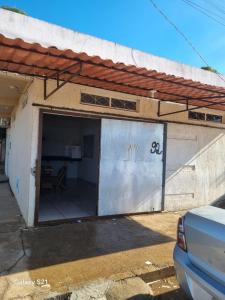 ein Gebäude mit einer Garage mit einem großen Tor in der Unterkunft Ney kitnet in Pirapora