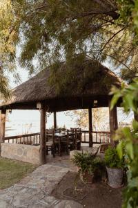 a pavilion with a table and chairs and the water at Garingboom Guest Farm in Groot-Suurfontein