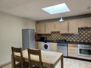 a kitchen with a wooden table and chairs in it at Salthill Gem in Galway