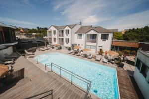 a large swimming pool on a deck next to a house at Le Thalassa Hôtel & Spa in Camaret-sur-Mer