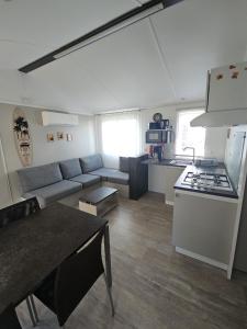 a living room with a couch and a kitchen at O'ContisParadise 2 in Saint-Julien-en-Born