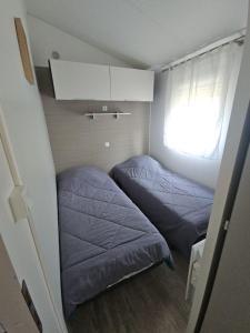 two beds in a small room with a window at O'ContisParadise 2 in Saint-Julien-en-Born +22 photos