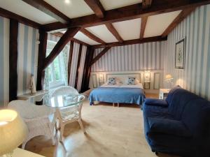 a bedroom with a bed and a table and a couch at Villa Ric in Saint-Céré