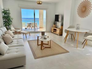 a living room with a white couch and a table at Front Line on the beach in Calpe