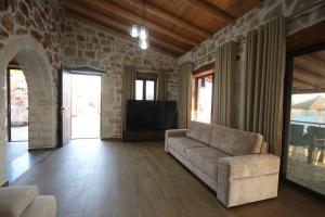 a living room with a couch and a tv at Villa ACROPOLIS in Jal