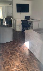 a room with a desk and a bed with a wooden floor at Casa com 2 quartos Mobiliada próxima ao Batel e Parque Barigui in Curitiba