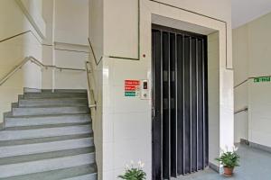 a staircase in a building with a black door at Hotel O Sunshine Inn in Nagpur +21 photos