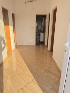 an empty room with a tile floor and a hallway at One floor of house in Bar