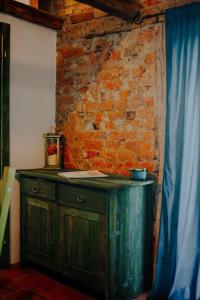 a wooden cabinet against a brick wall with a blue curtain at Kuća za odmor Odvorci in Jakačina Mala +50 photos