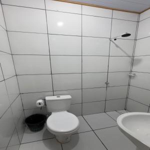 a white bathroom with a toilet and a sink at Amazon Anavilhanas Lodge in Aiparuça