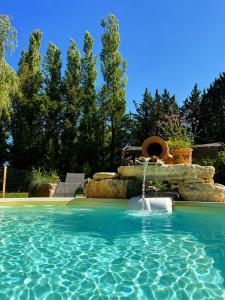 a pool with a water fountain in a yard at Gîte Moulin de l'Anet in Goult